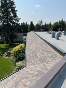 Installation of the eavestrough liner and cap flashing along the front of the church.