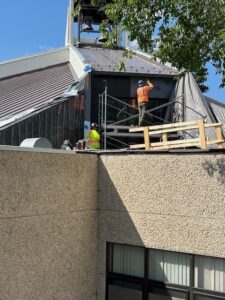 Installing metal clad above the NE stained glass windows